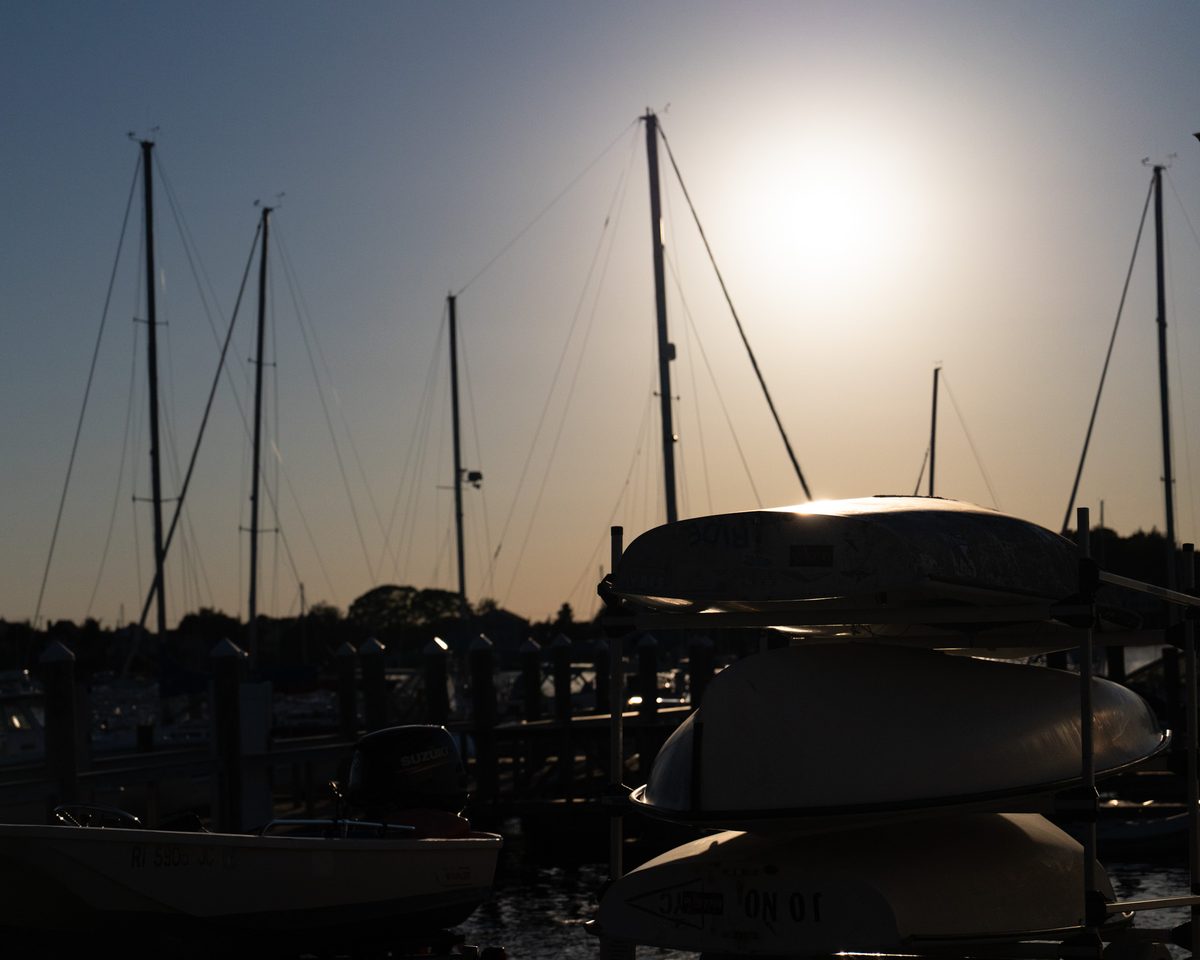 Dinghies racked upside down at a marina at sunset
